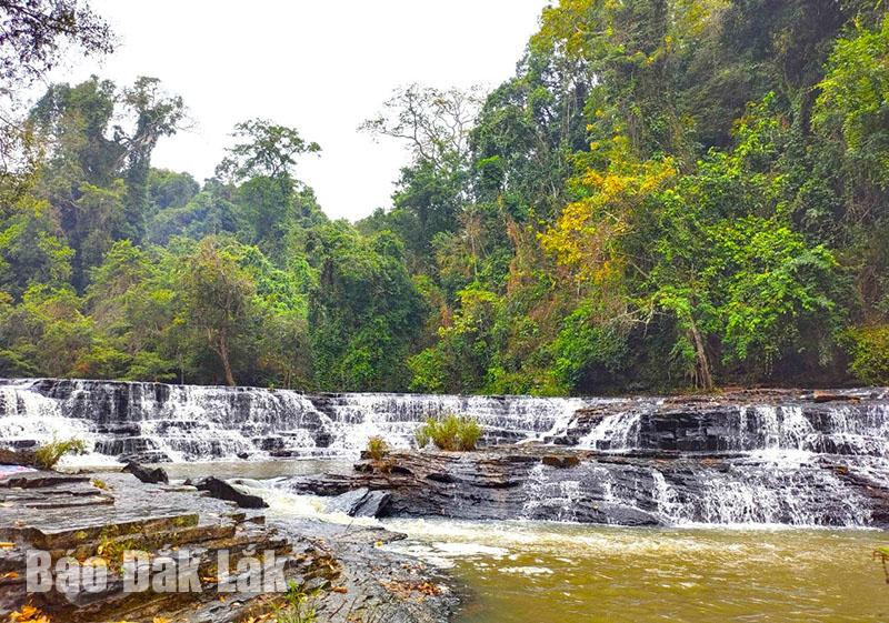 Vẽ cảnh quan thiên nhiên với thác nước Thủy Tiên Đắk Lắk, tập trung vào sự mềm mại và uyển chuyển của dòng nước